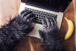 gorilla hands on a macbook with a banana